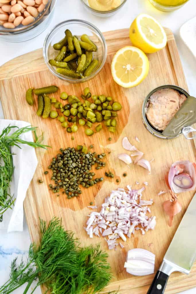 French-Style Tuna White Bean Salad being prepared on a cutting board.